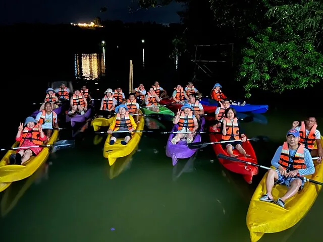 Groupe de touristes faisant du kayak de nuit sur la rivière Abatan